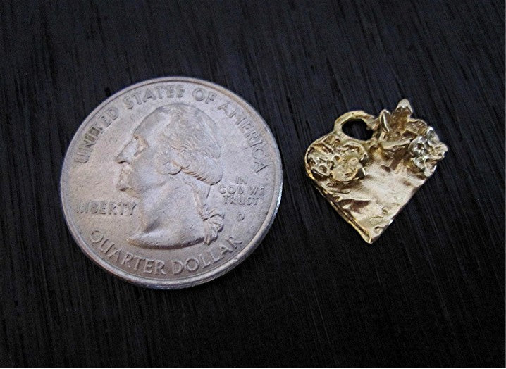 VDI Jewelry Findings Gold Bronze Heart Charm with Flower Accents next to quarter