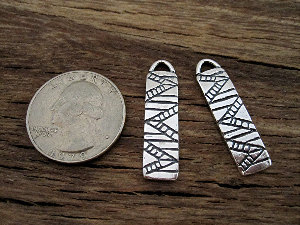 Two Sterling Silver Southwest Style Earring Dangles Next to a Quarter