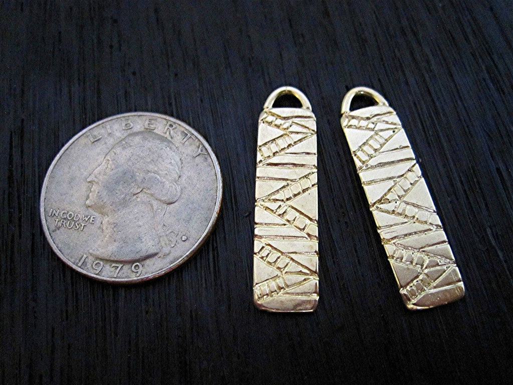 Two Gold Bronze Southwest Style Earring Dangles Next to Quarter