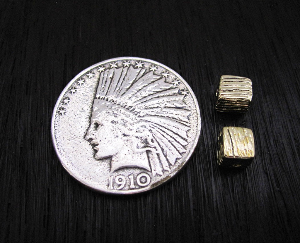 Small Gold Bronze Textured Cubed Spacer Bead next to a Quarter