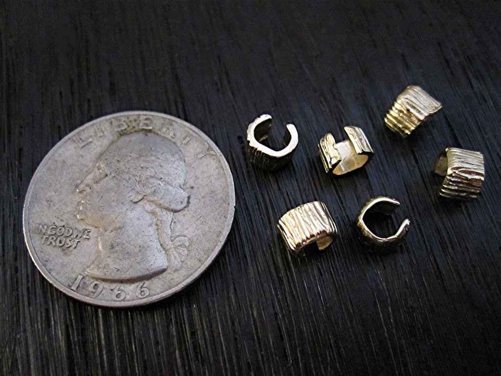 VDI Jewelry Findings Gold Bronze Lined Crimp Bead Covers Next to a Quarter