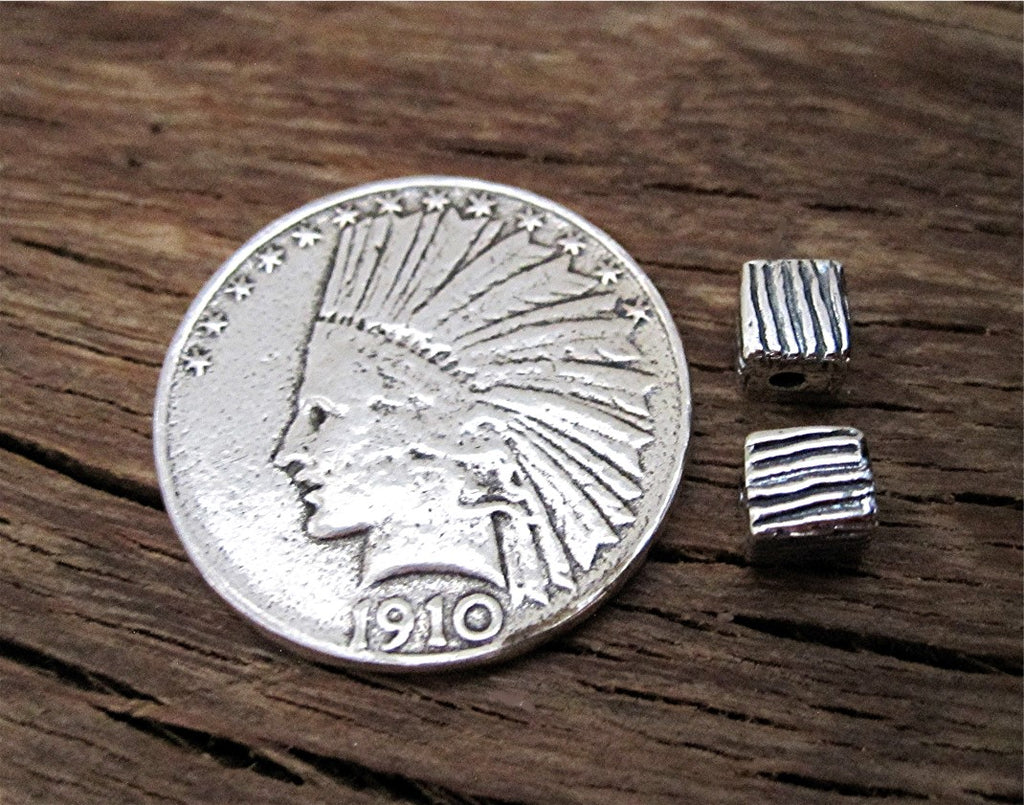 Small Sterling Silver Lined Cubed Jewelry Beads next to a Quarter