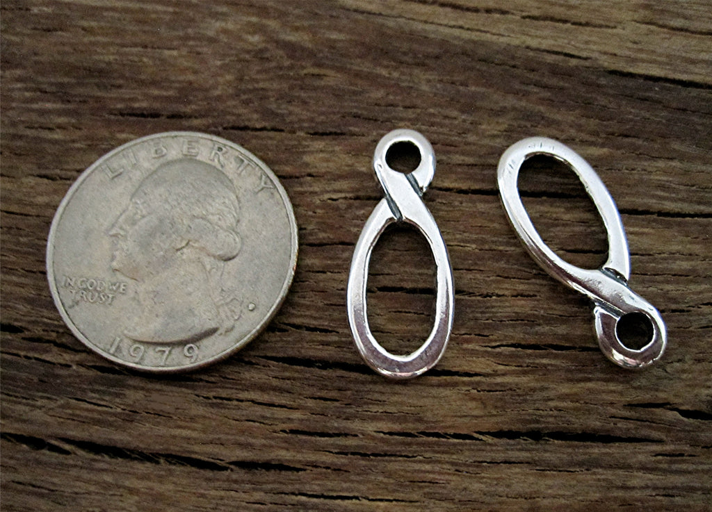 Sterling Silver Jewelry Link next to a Quarter